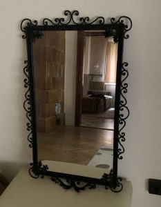 A beautiful mirror in a wrought iron frame is for sale